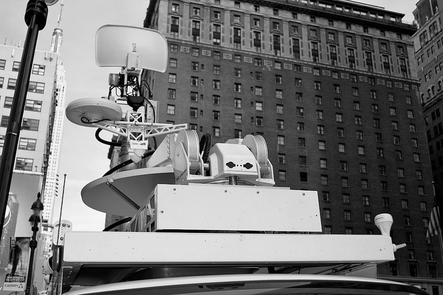 Black and white broadcast satellite dish on news van roof