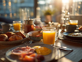 Sunlit Breakfast Table with Croissants, Eggs, and Orange Juice