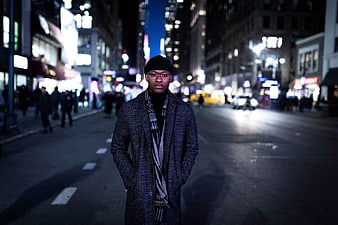 Stylish Man in Coat Standing on City Street at Night