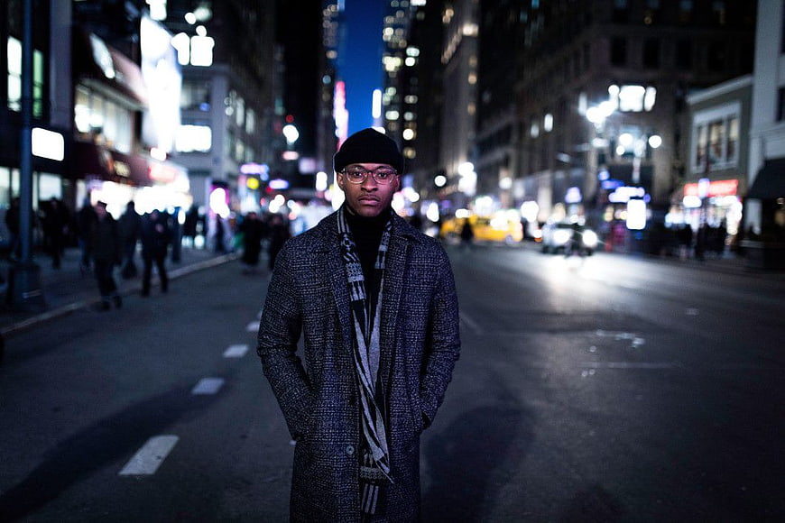 Stylish Man in Coat Standing on City Street at Night