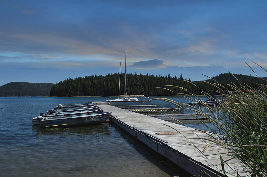 Wooden dock with boats on a calm lake at sunset