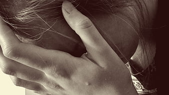 Close-up of woman holding head in despair and grief