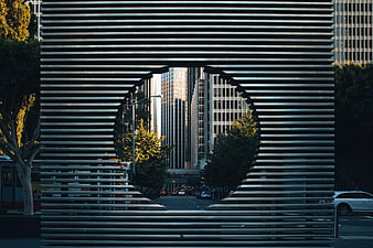 Modern metal slat sculpture framing city street view