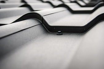 Close-up of gray metal roof tiles with screw detail