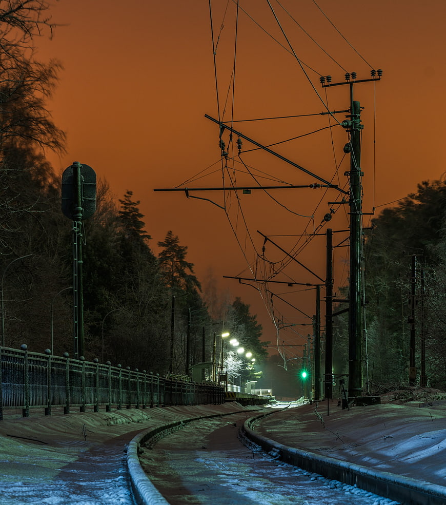 Snowy Train Tracks at Night with Orange Sky