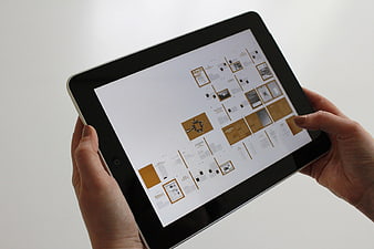 Hands holding tablet displaying digital interface