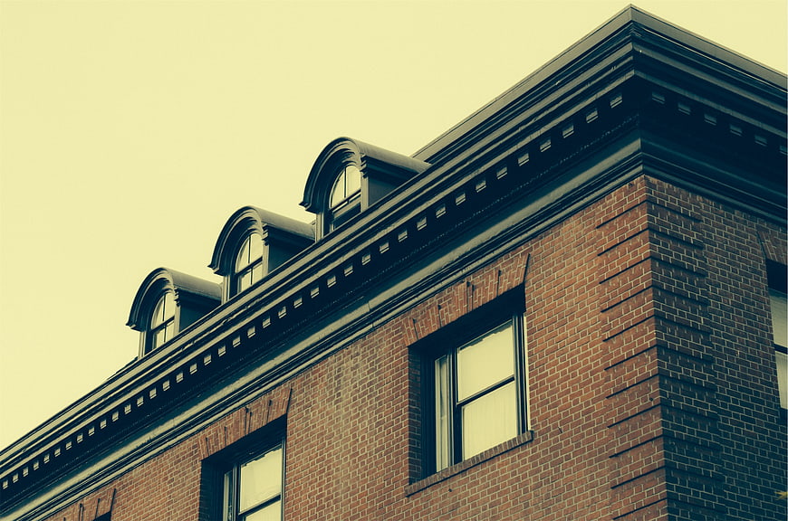 Low angle view of red brick building with dormer windows