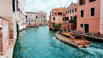Wooden Motorboat Gliding Through Turquoise Venice Canal