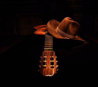 Classical Guitar and Cowboy Hat in Dramatic Dark Lighting