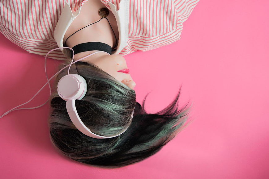 Woman with Headphones on Pink Background