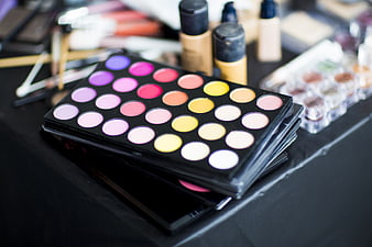 Colorful eyeshadow palette with makeup brushes and foundation