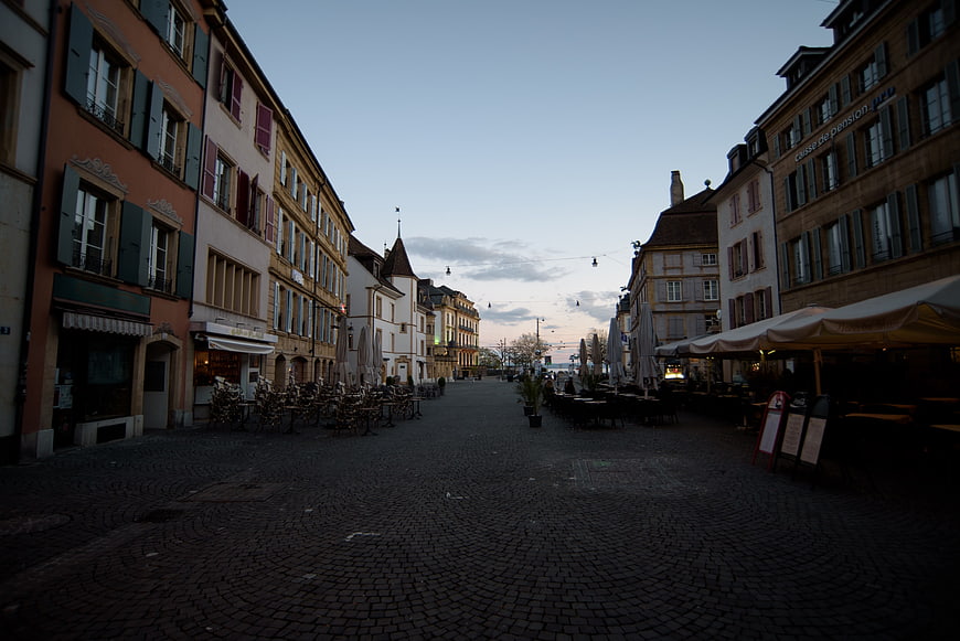 Empty cobblestone European street at dusk with cafes