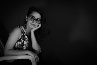Black and white portrait of a smiling woman with glasses