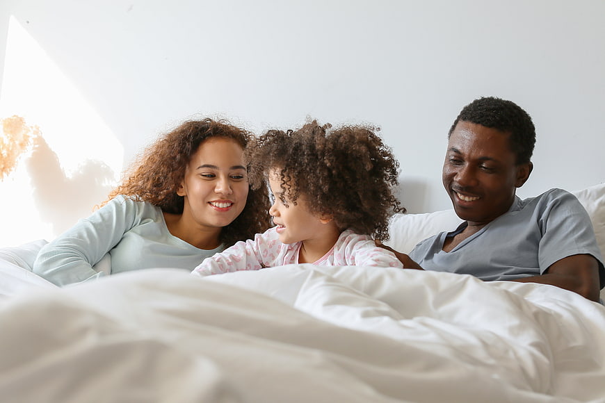 Happy African American Family in Bed Together