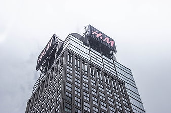 Low angle view of H&M sign on modern skyscraper