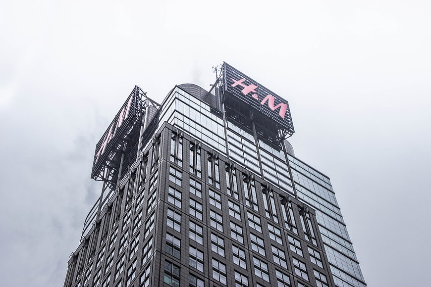 Low angle view of H&M sign on modern skyscraper