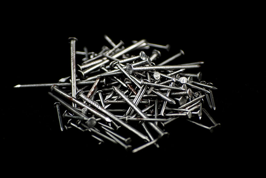 Pile of Silver Metal Nails on Black Background