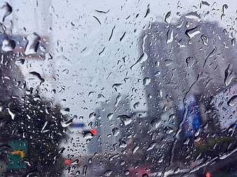 Raindrops on Window Glass with Blurred City Background