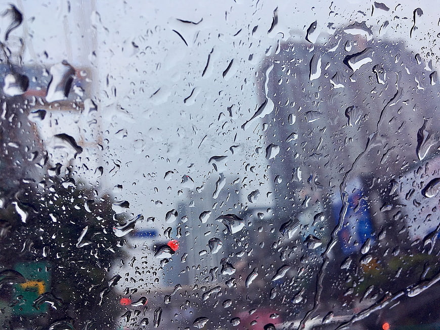 Raindrops on Window Glass with Blurred City Background