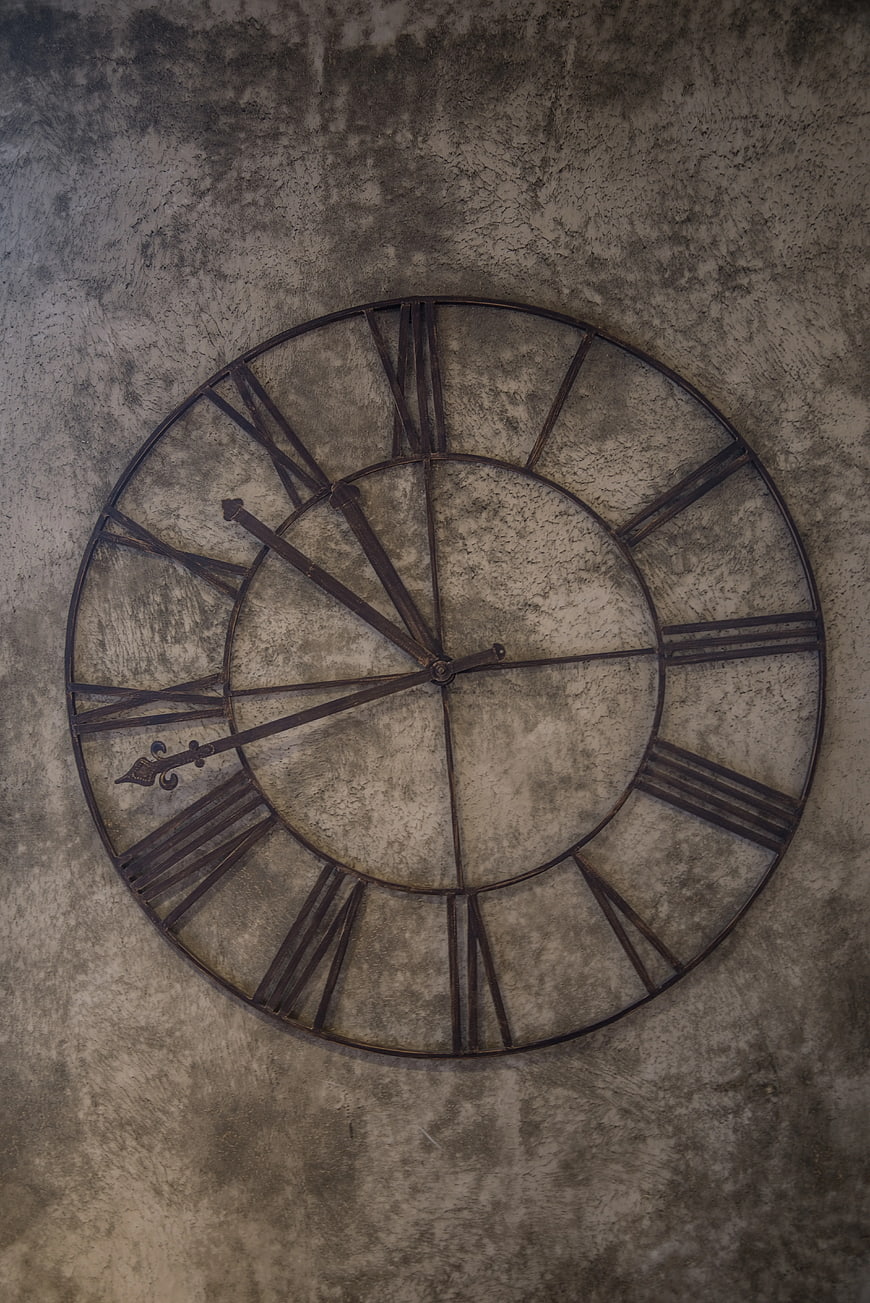 Vintage Metal Wall Clock on Textured Concrete Wall