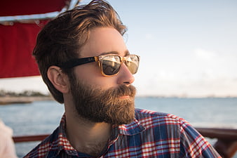 Bearded Man in Sunglasses on Boat at Sunset