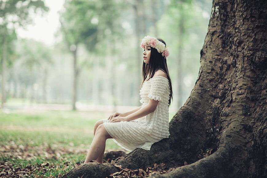 Woman in White Dress Sitting by Tree in Park
