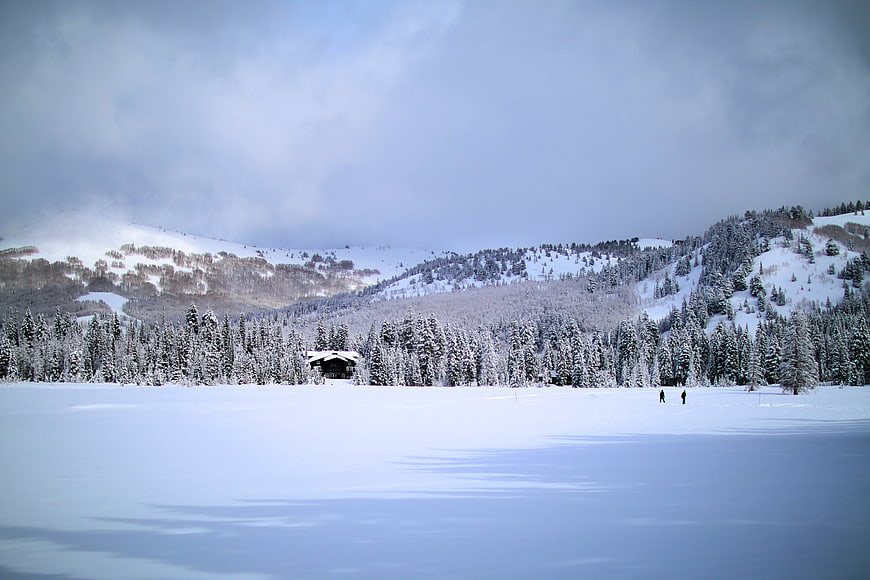 Serene Winter Landscape with Snowy Mountains and Cabin