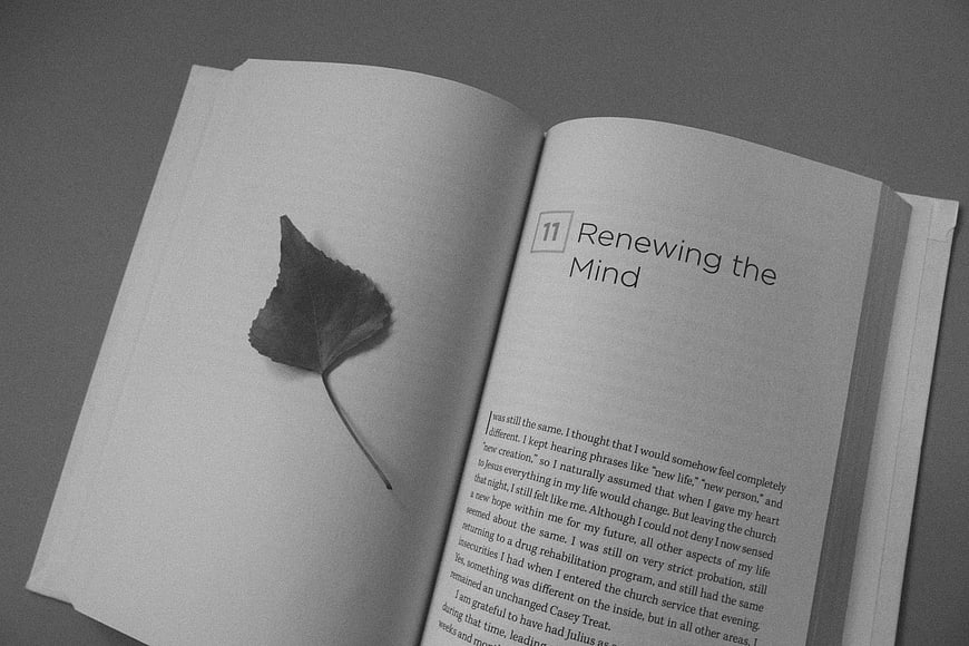 Open book with leaf bookmark and chapter title Renewing the Mind