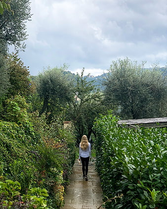 Woman Walking Away on Wet Garden Path