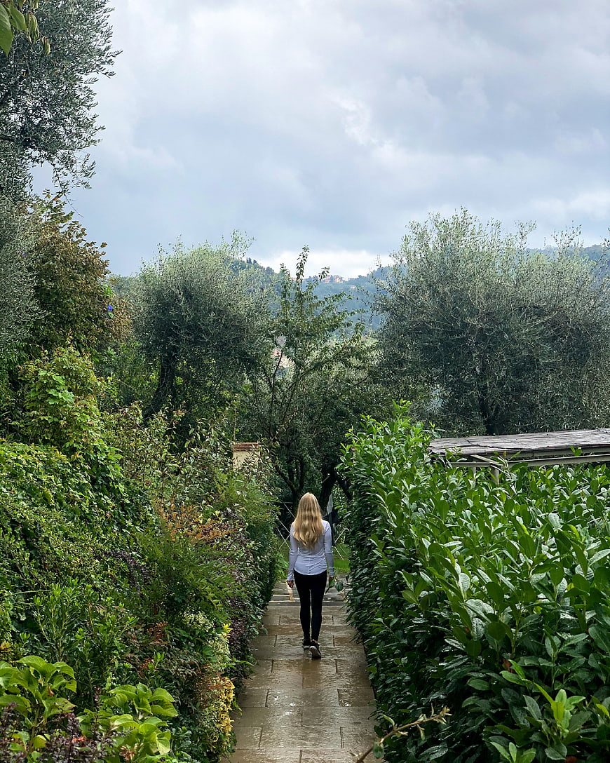 Woman Walking Away on Wet Garden Path
