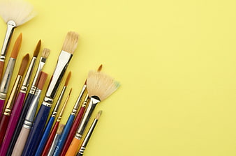 Assorted Paint Brushes on Yellow Background