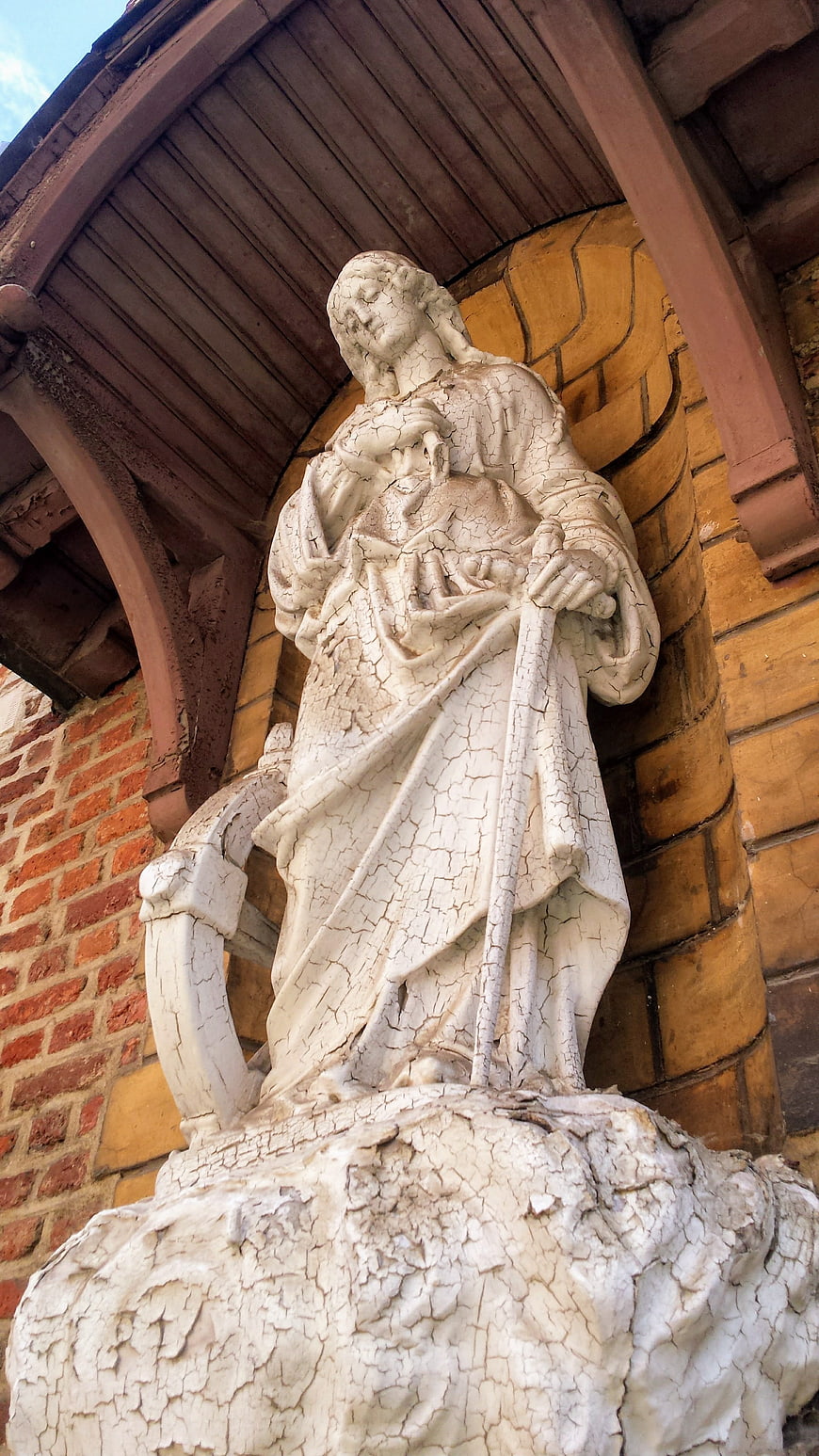Weathered White Religious Statue in Architectural Niche