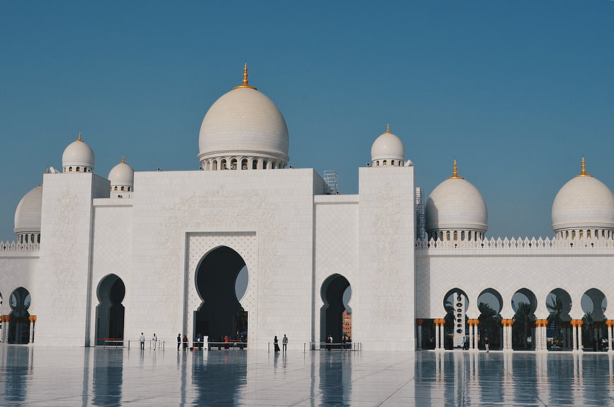 Sheikh Zayed Grand Mosque exterior with white marble domes and reflections