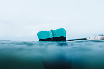 Close-up of teal boat rudder in ocean water