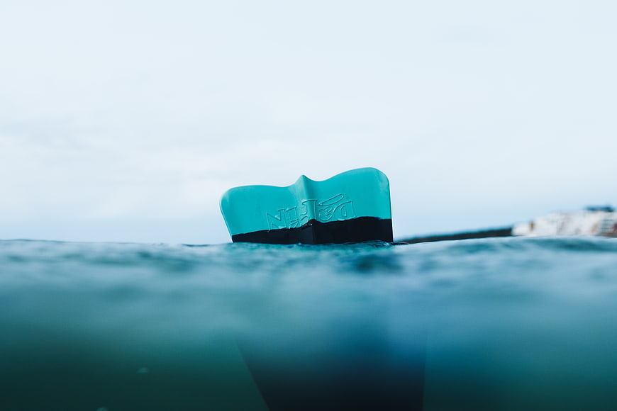 Close-up of teal boat rudder in ocean water