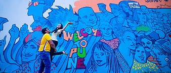 Couple posing in front of colorful Welcome to Pune mural