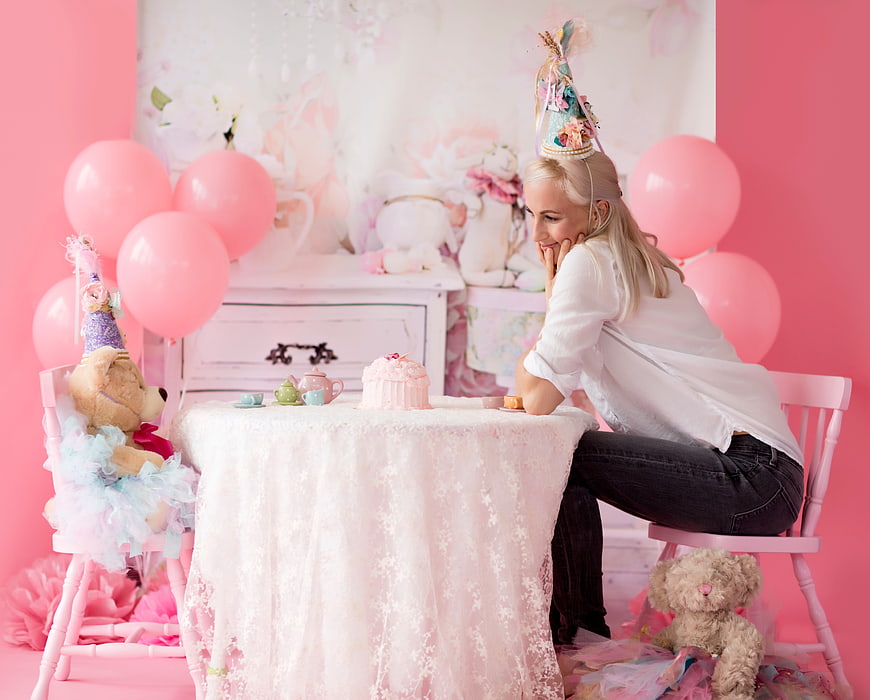 Woman having a whimsical tea party with teddy bears