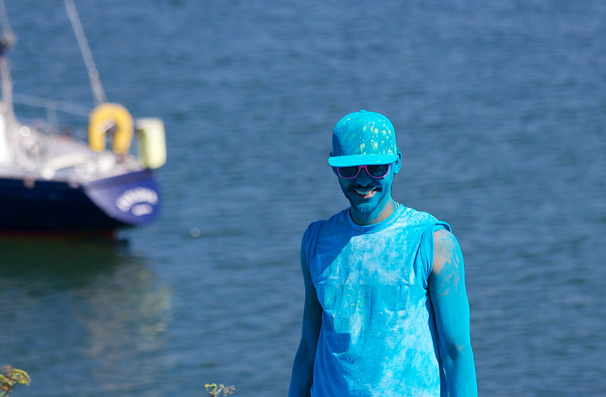 Man Covered in Blue Powder Paint by the Sea