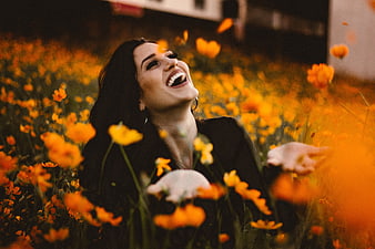 Happy Woman Laughing in Orange Flower Field