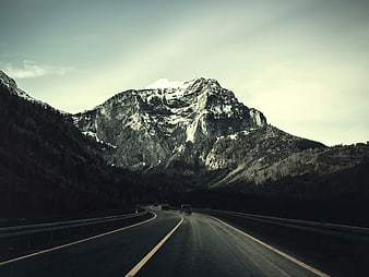 Winding Mountain Road with Snow-Capped Peak and Forest
