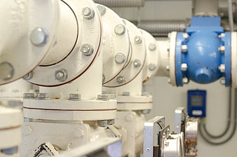 Close-up of white industrial pipes and blue valve