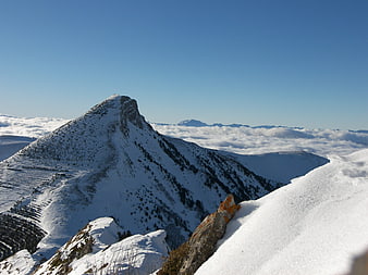 Snowy Mountain Peak Above Sea of Clouds in Winter