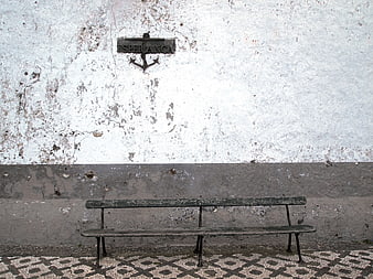 Weathered Bench Against Textured Wall with Esperanca Sign