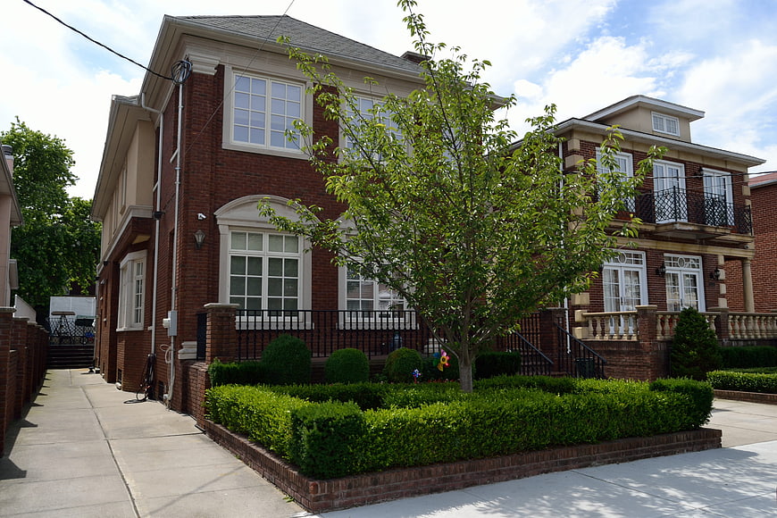 Exterior View Of A Two-Story Brick Residential House With Landscaped Garden