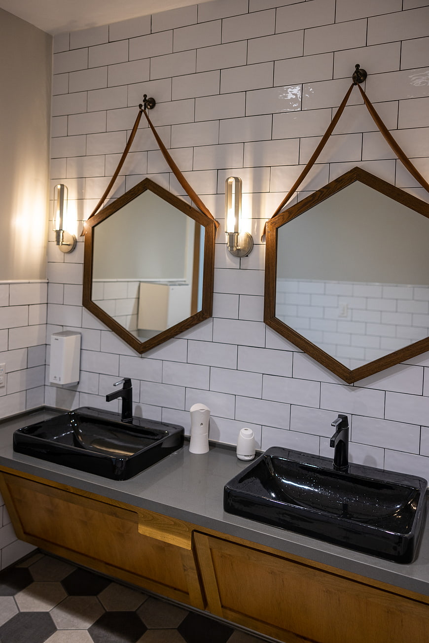 Modern Bathroom Interior with Black Sinks and Hexagonal Mirrors