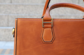 Close-up of handmade tan leather handbag with gold hardware