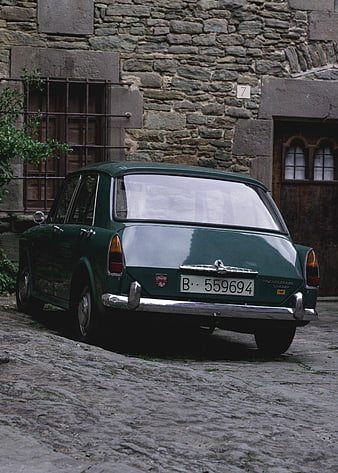 Vintage Green Volvo 142S Parked on Cobblestone Street