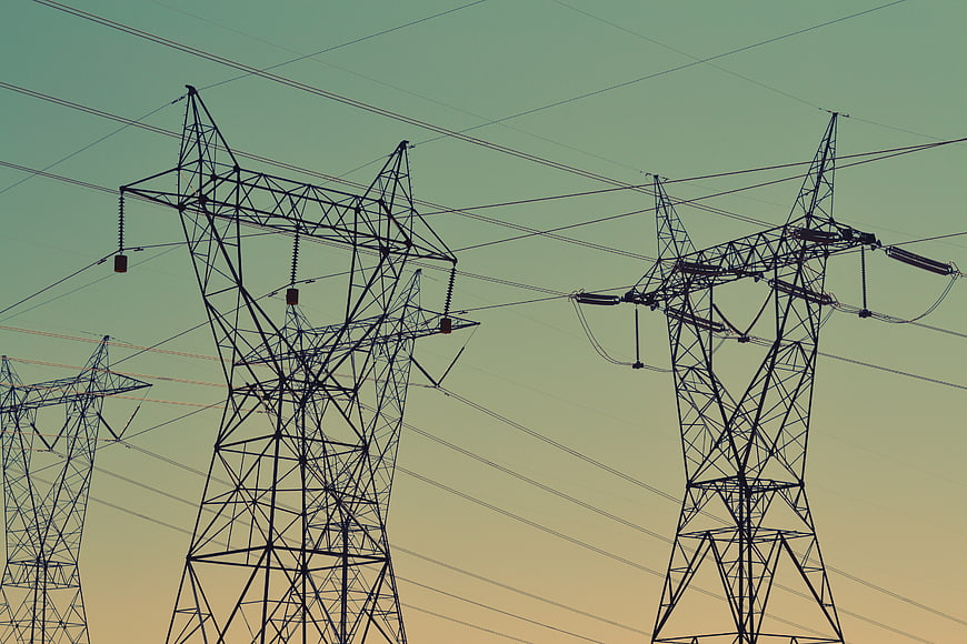 Silhouetted High Voltage Power Lines Against Gradient Sky