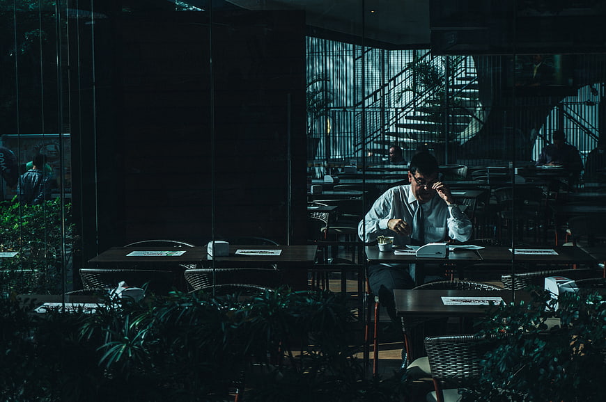 Man working alone in dimly lit modern office cafe