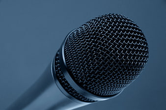 Close-up of black microphone head on blue background